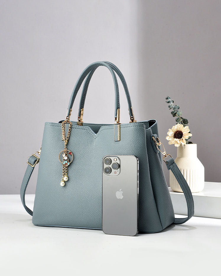 Bolso de mano y hombro con dije decorativo