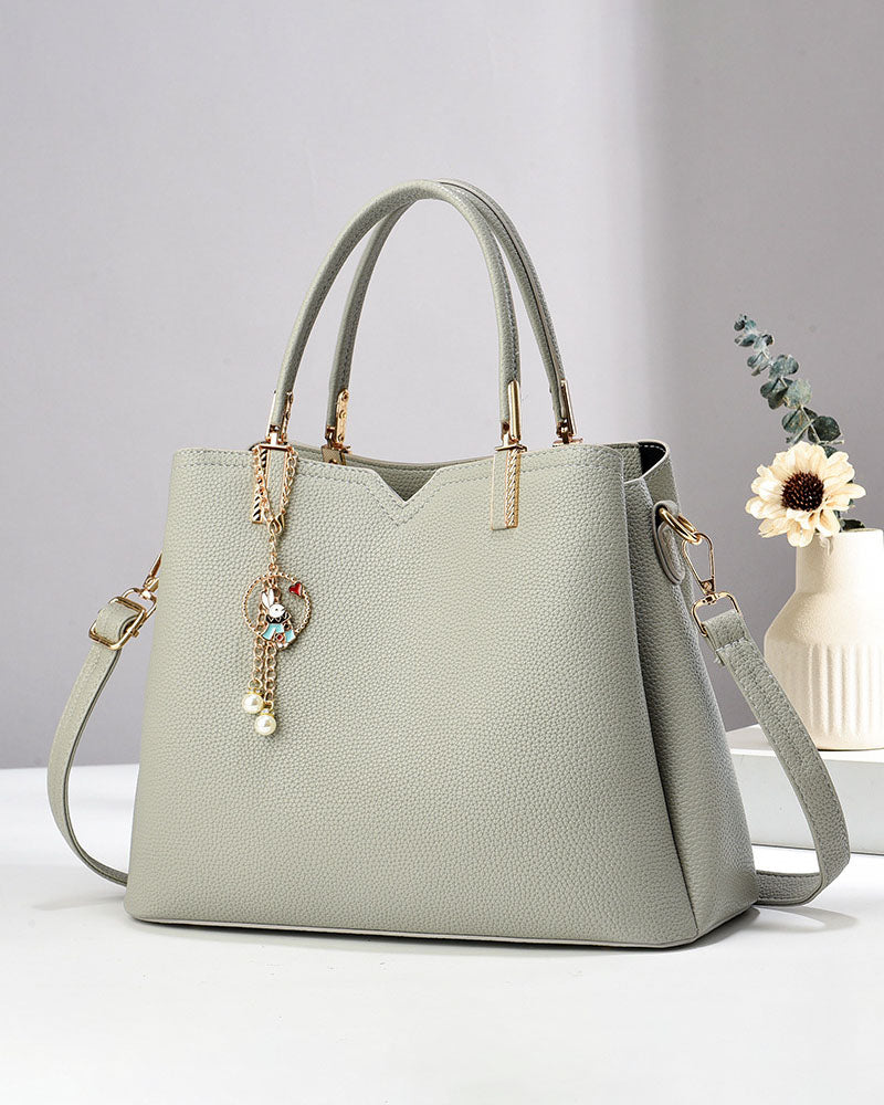 Bolso de mano y hombro con dije decorativo