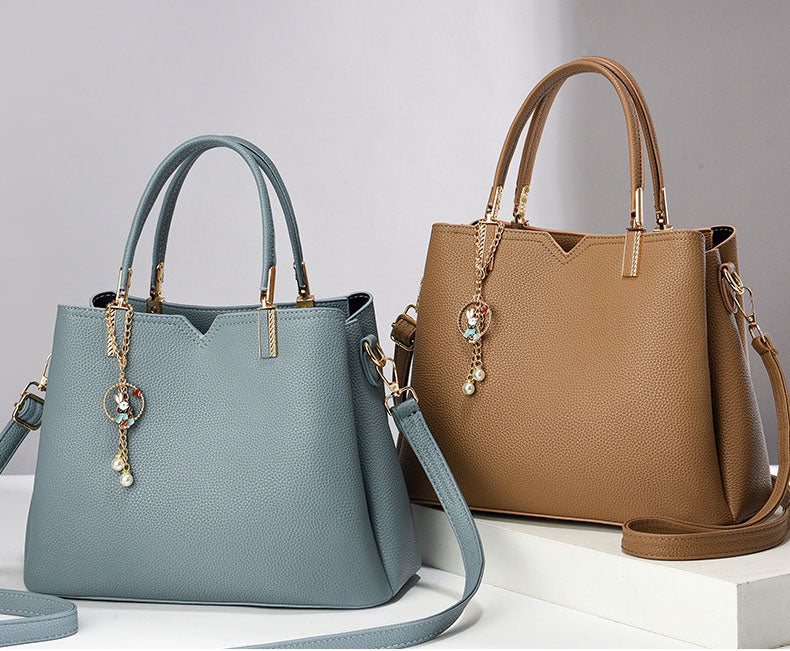 Bolso de mano y hombro con dije decorativo
