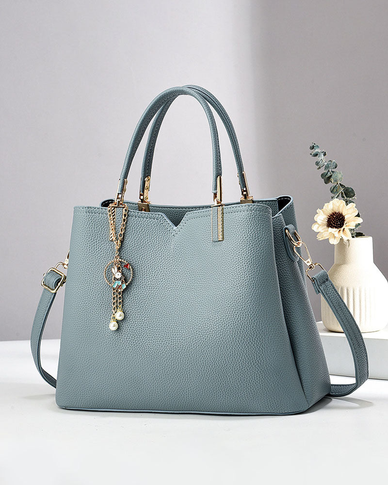 Bolso de mano y hombro con dije decorativo