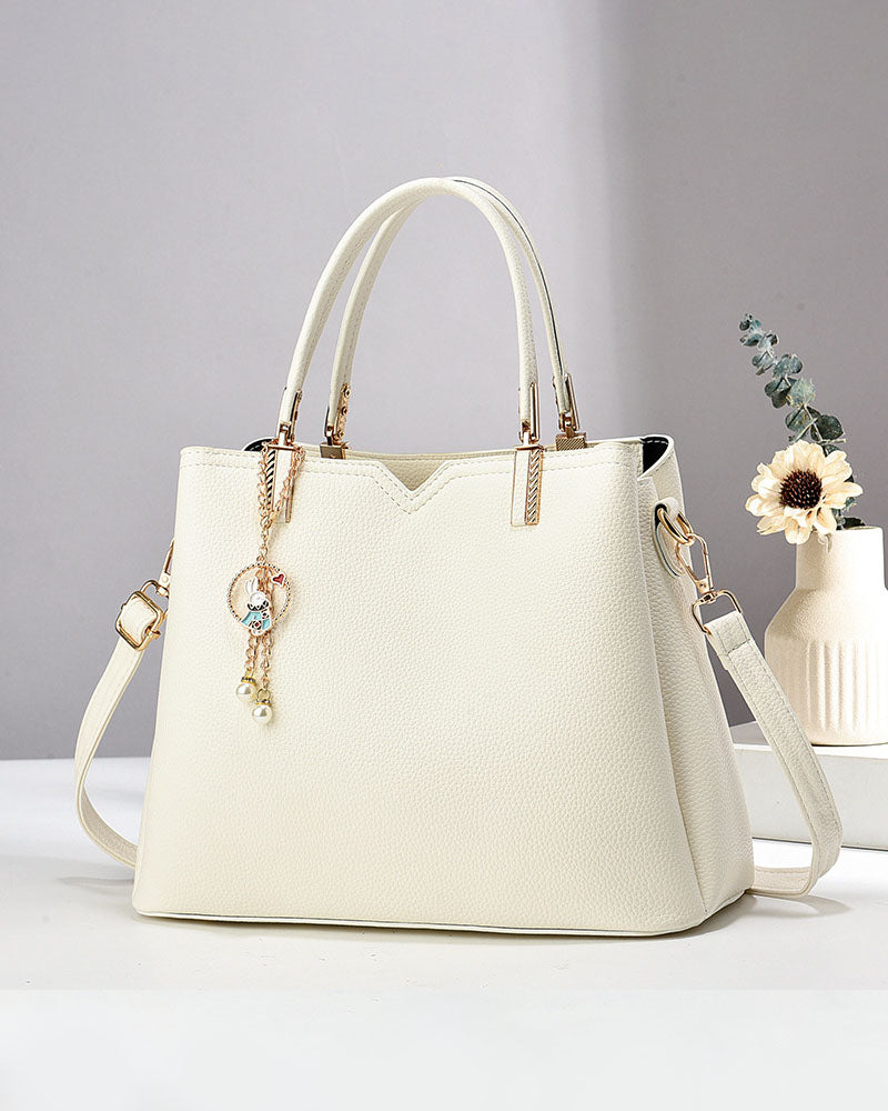 Bolso de mano y hombro con dije decorativo