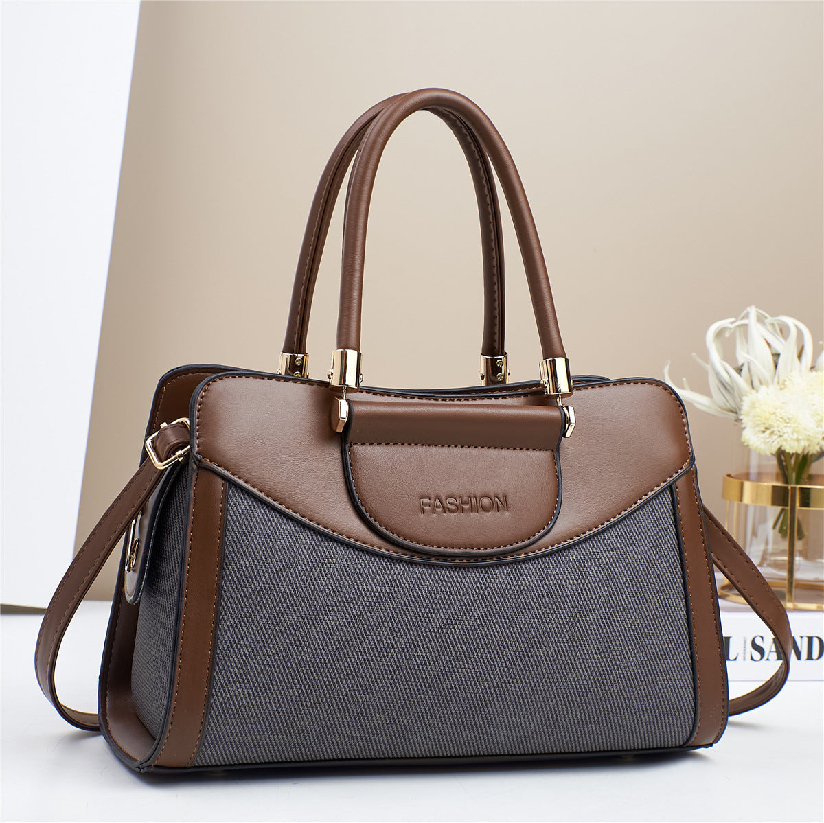 Bolso medianao con estructura rectangular, doble asa y correa ajustable