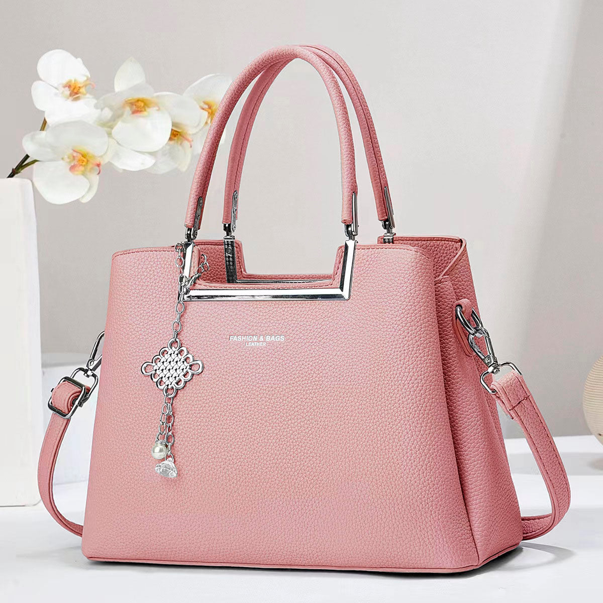 Bolso de mano con asas doble, correa de hombro desmontable. Dije decorativo plateado