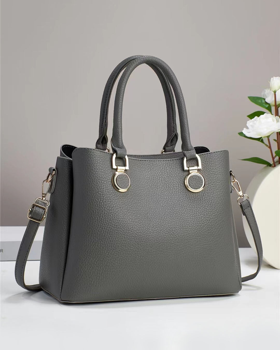 Bolso elegante de doble asa con aros decorativos