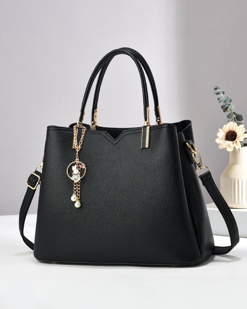 Bolso de mano y hombro con dije decorativo
