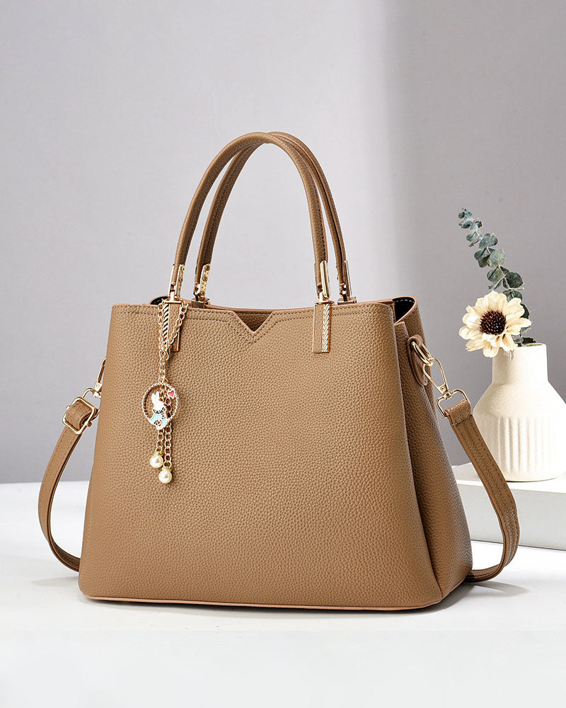 Bolso de mano y hombro con dije decorativo
