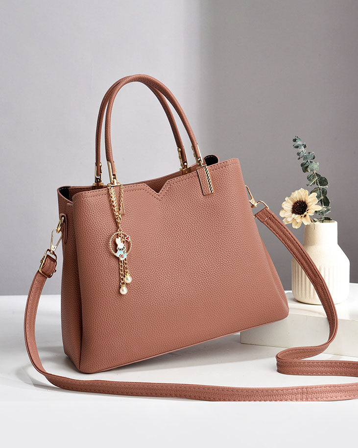 Bolso de mano y hombro con dije decorativo