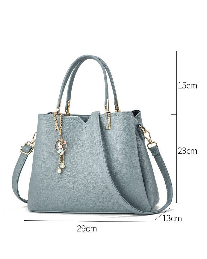 Bolso de mano y hombro con dije decorativo