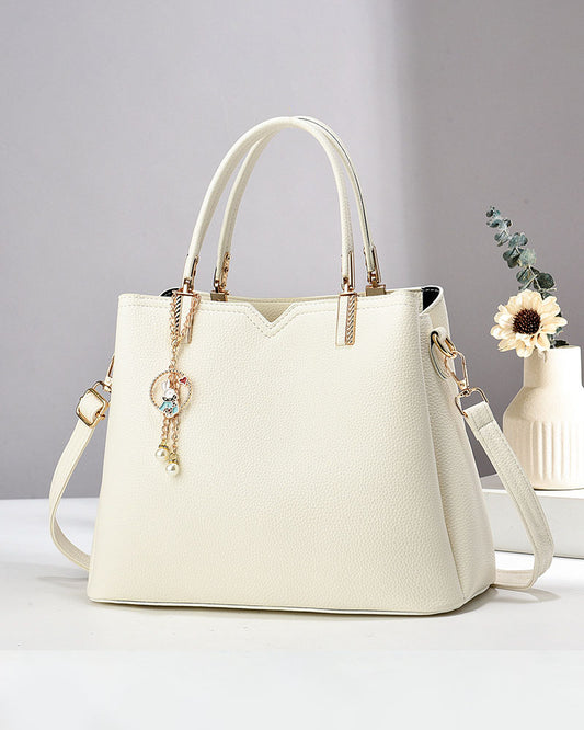 Bolso de mano y hombro con dije decorativo