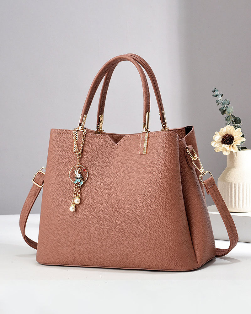 Bolso de mano y hombro con dije decorativo