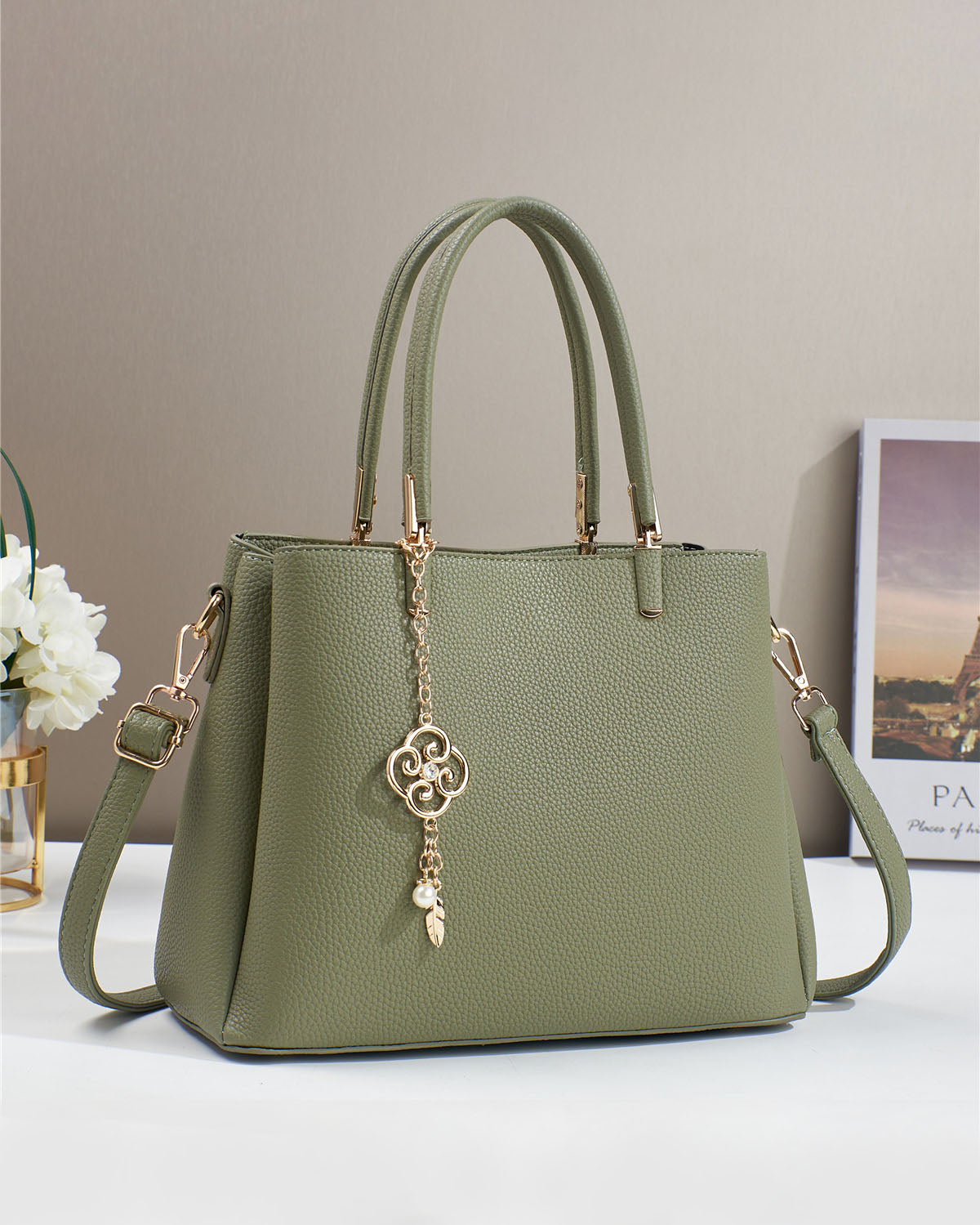 Bolso con dije decorativo y detalles en dorado