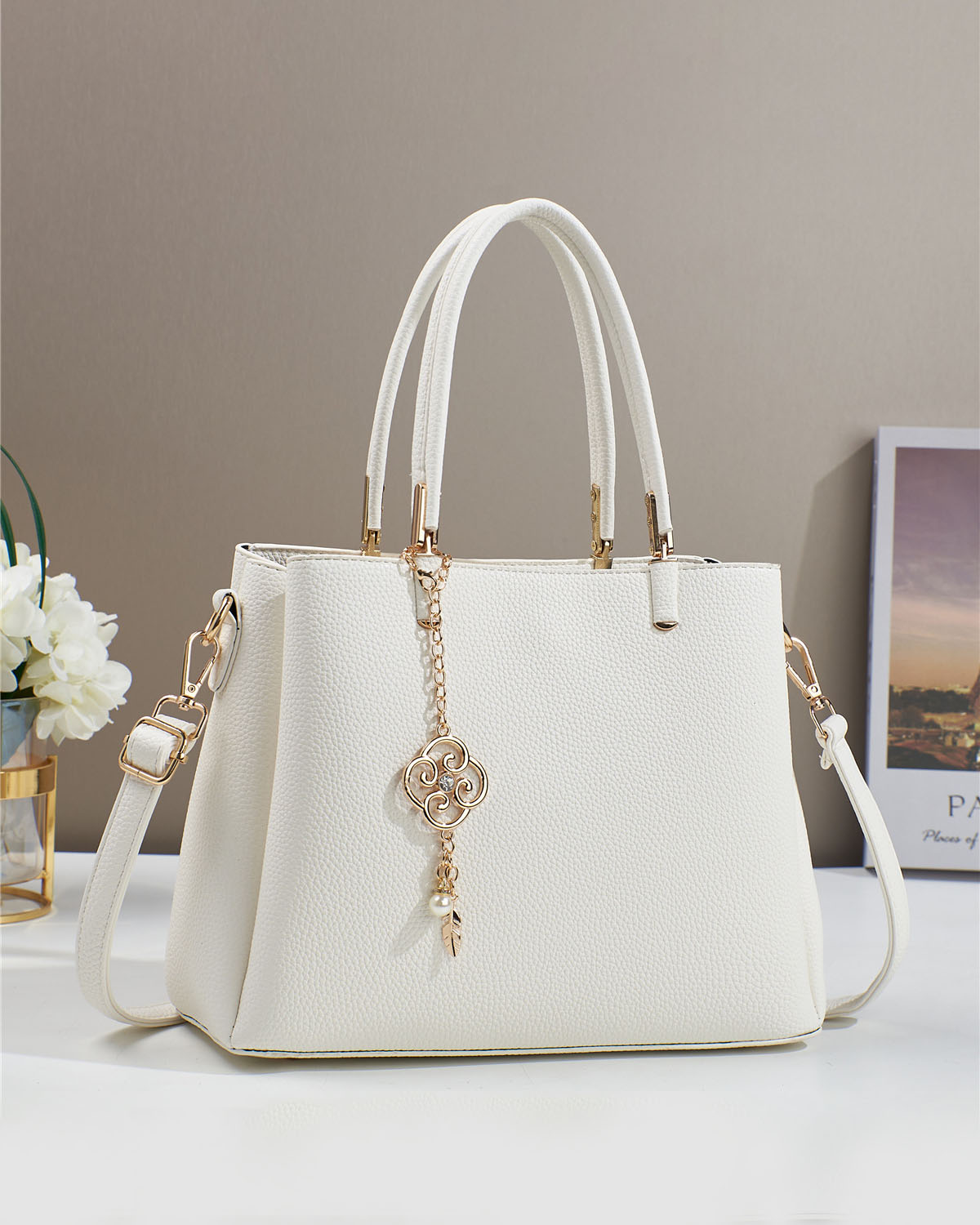 Bolso con dije decorativo y detalles en dorado