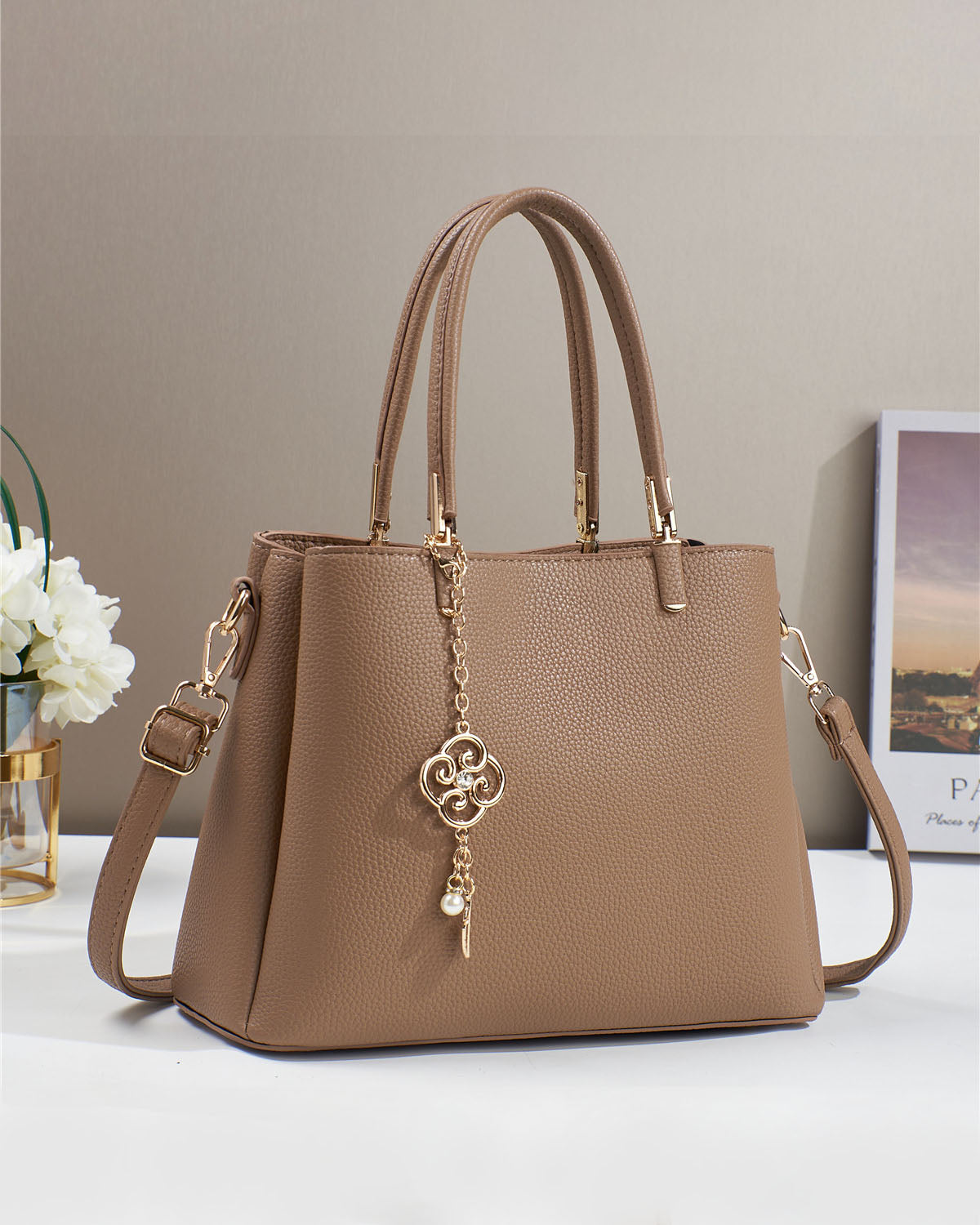 Bolso con dije decorativo y detalles en dorado