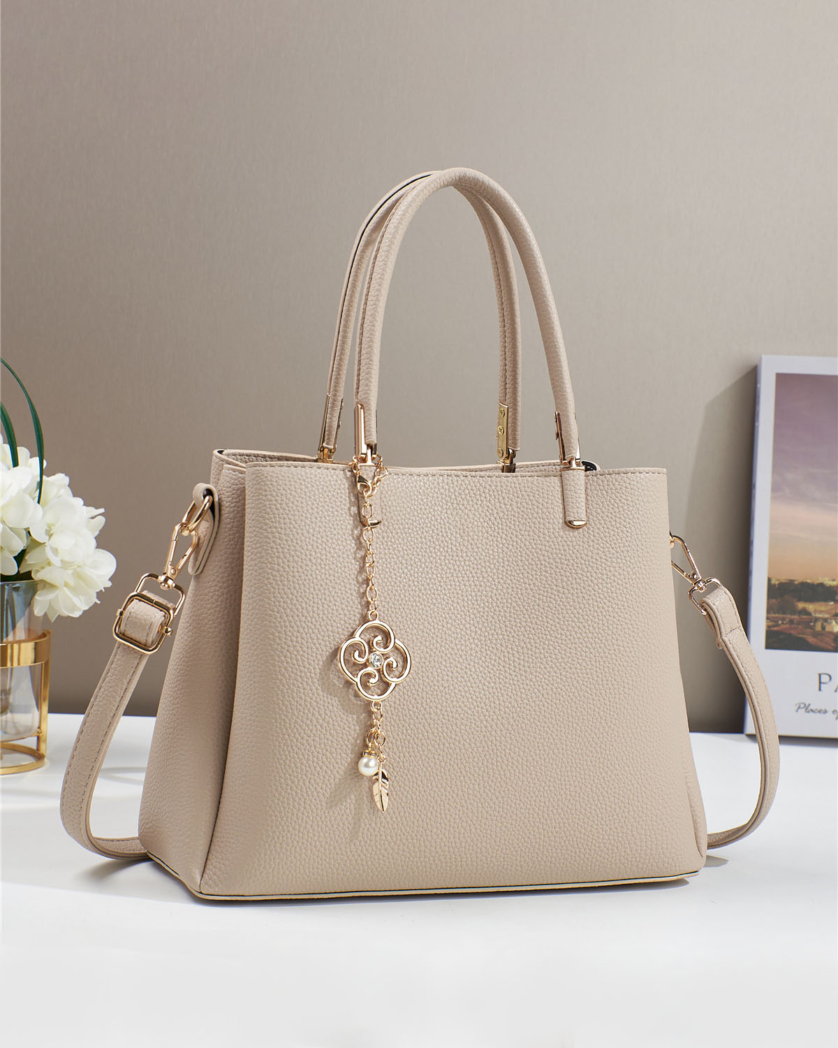 Bolso con dije decorativo y detalles en dorado