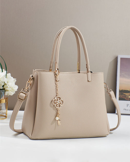 Bolso con dije decorativo y detalles en dorado