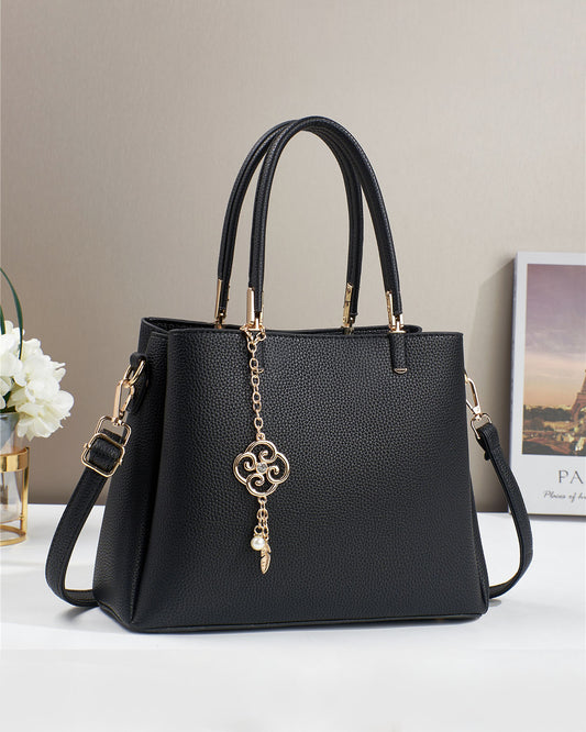 Bolso con dije decorativo y detalles en dorado