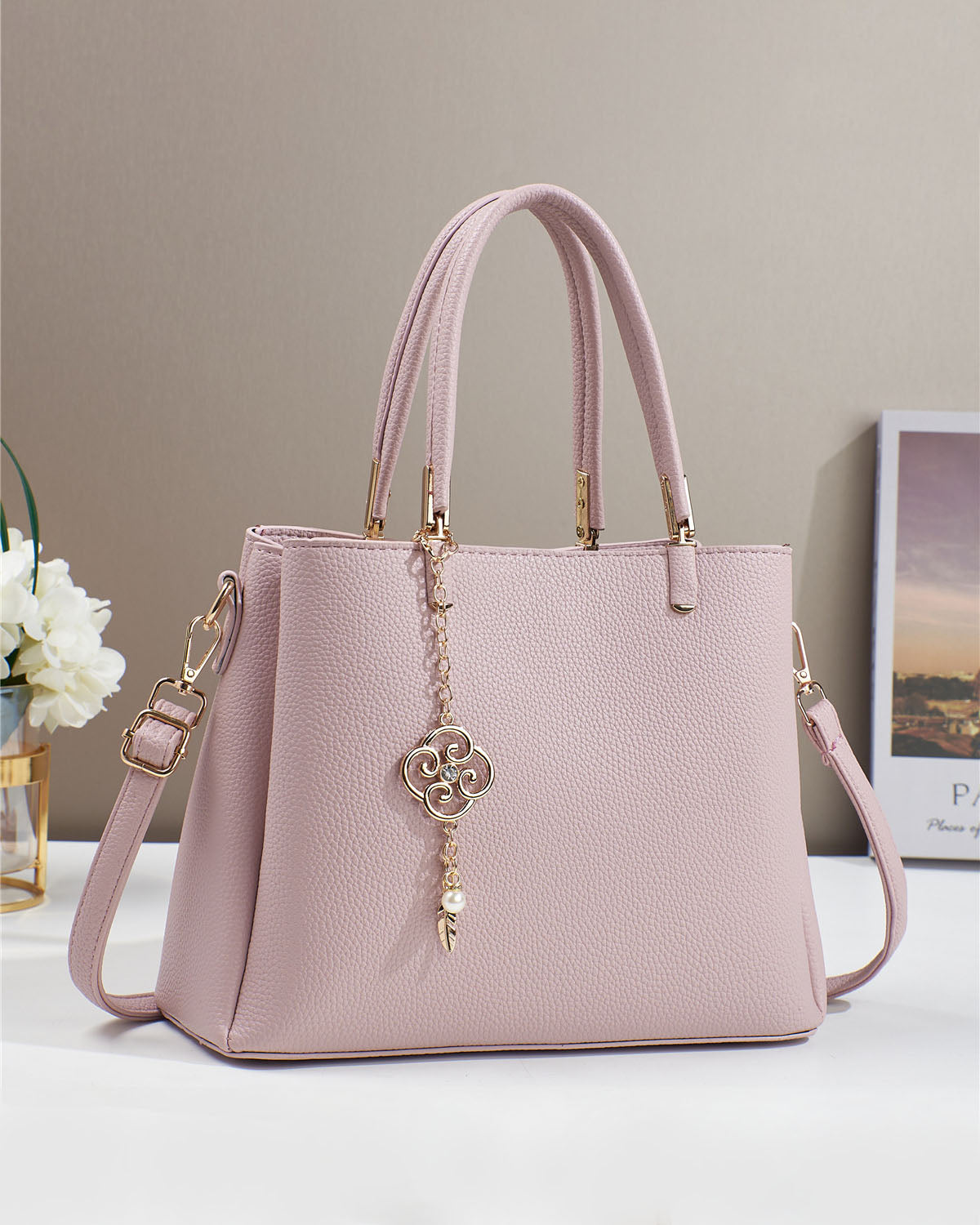 Bolso con dije decorativo y detalles en dorado