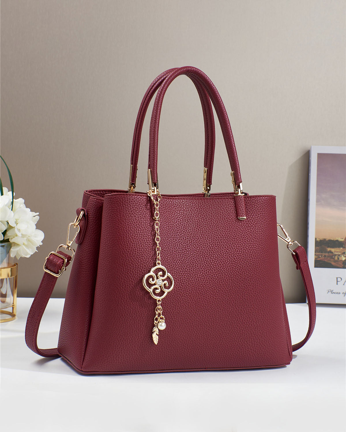 Bolso con dije decorativo y detalles en dorado