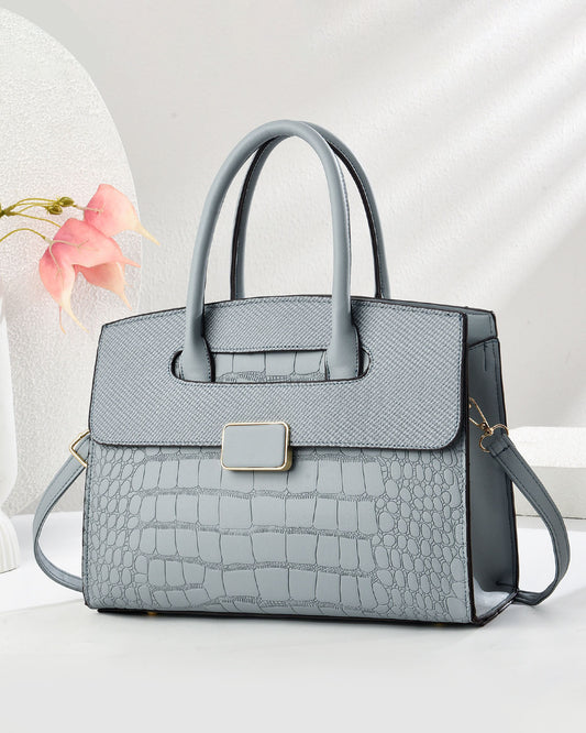 Bolso mediano con textura tipo cocodrilo y hebilla frontal