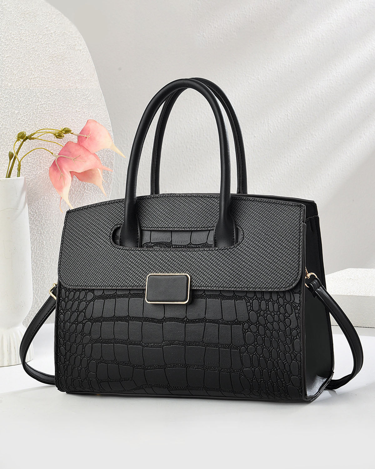 Bolso mediano con textura tipo cocodrilo y hebilla frontal