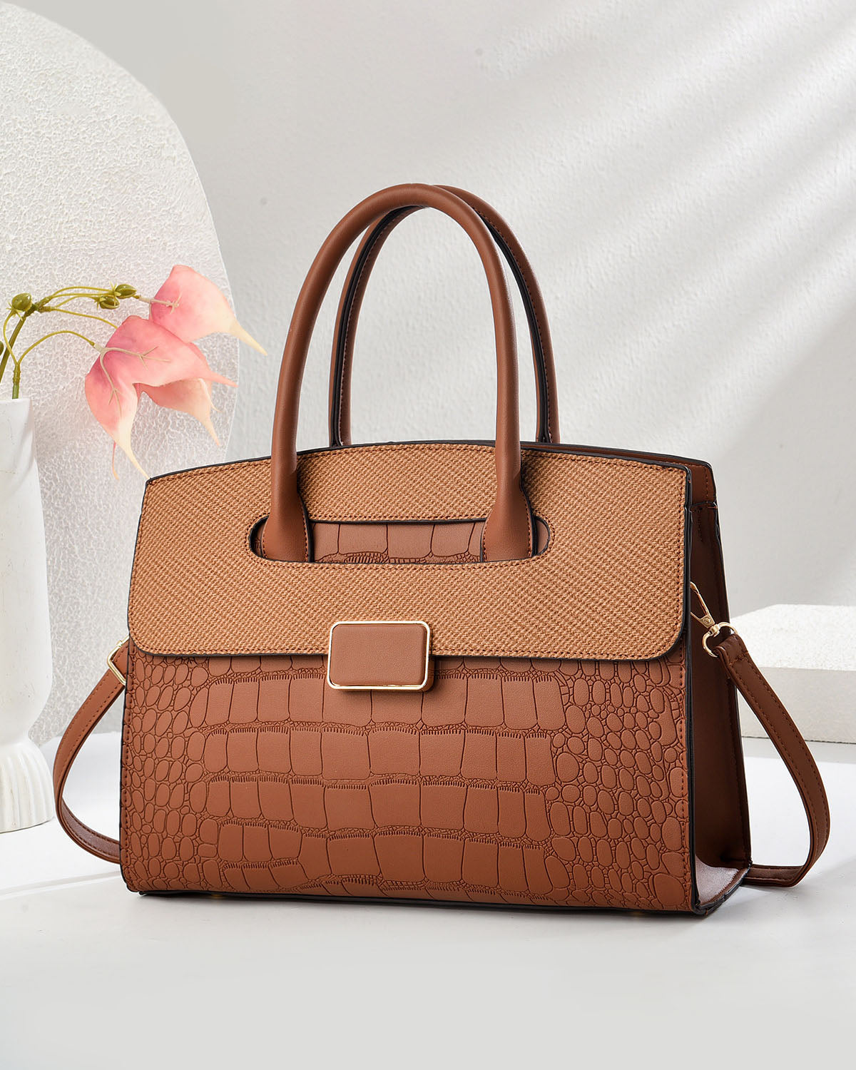 Bolso mediano con textura tipo cocodrilo y hebilla frontal