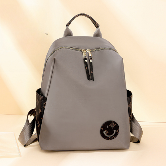 Mochila en tela con parche con carita sonriente, bolsillos laterales en marron