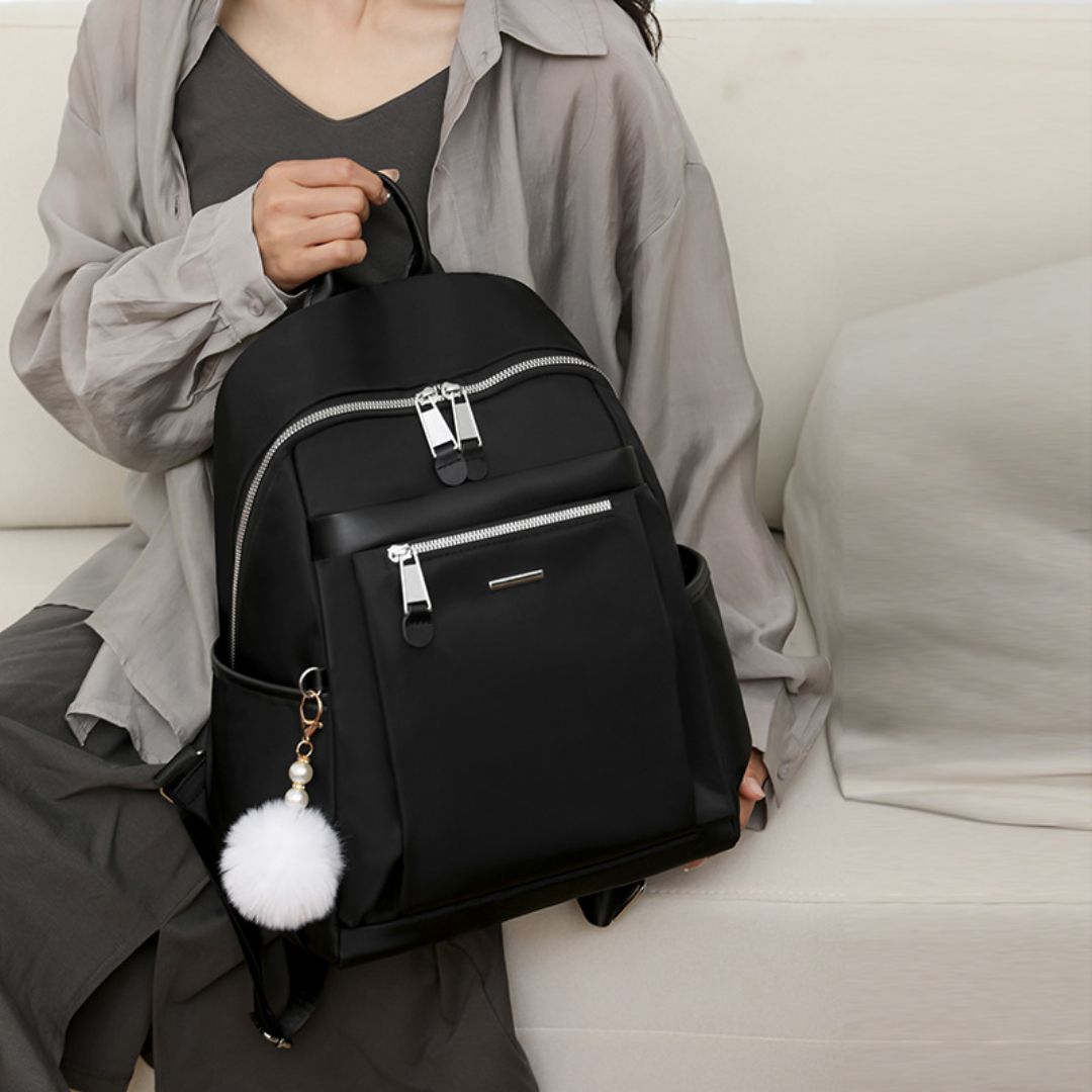 Mochila en tela con compartimentos, llavero pompón y asa superior