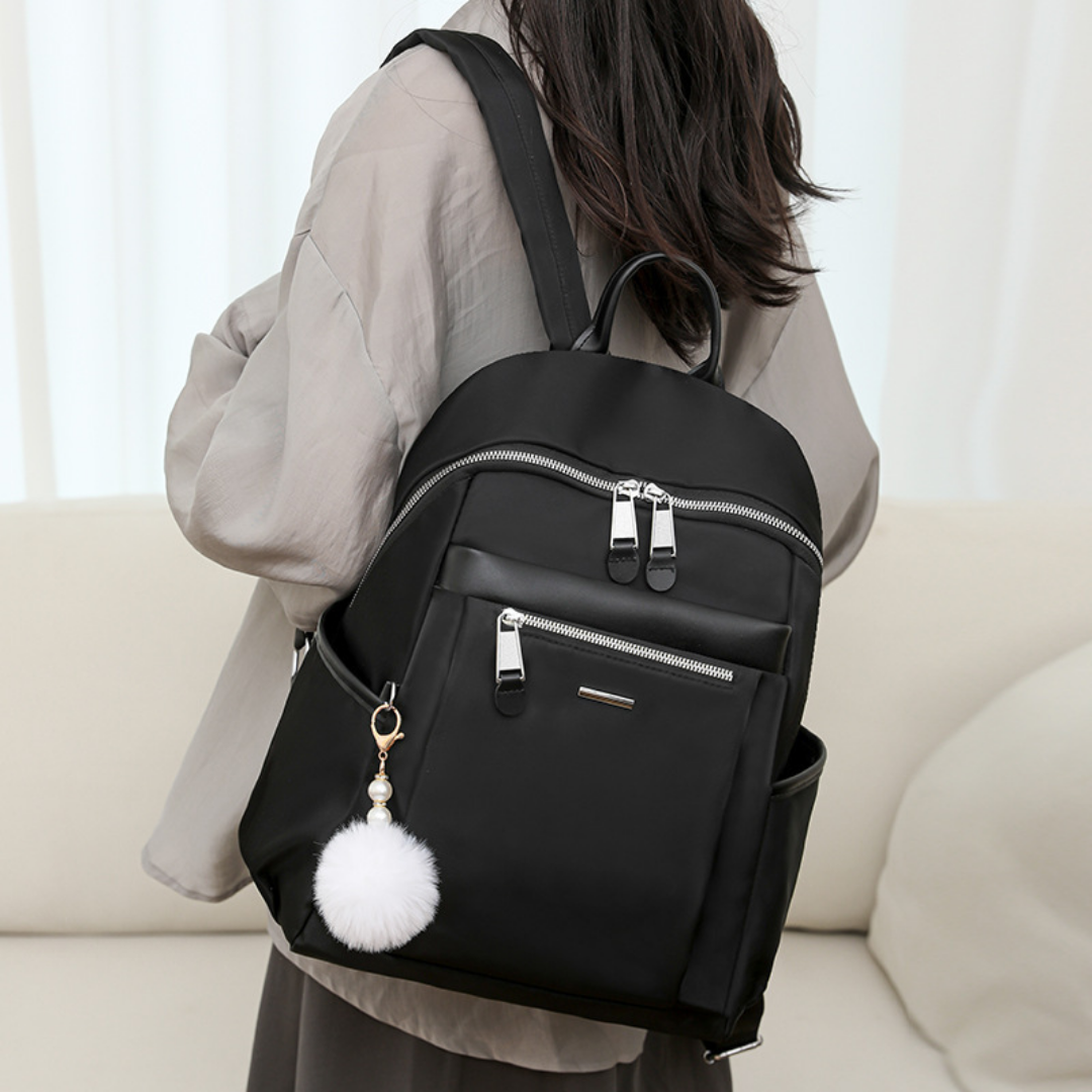 Mochila en tela con compartimentos, llavero pompón y asa superior