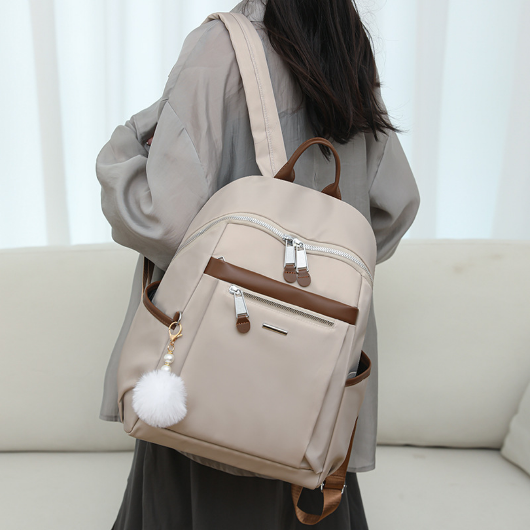 Mochila en tela con compartimentos, llavero pompón y asa superior