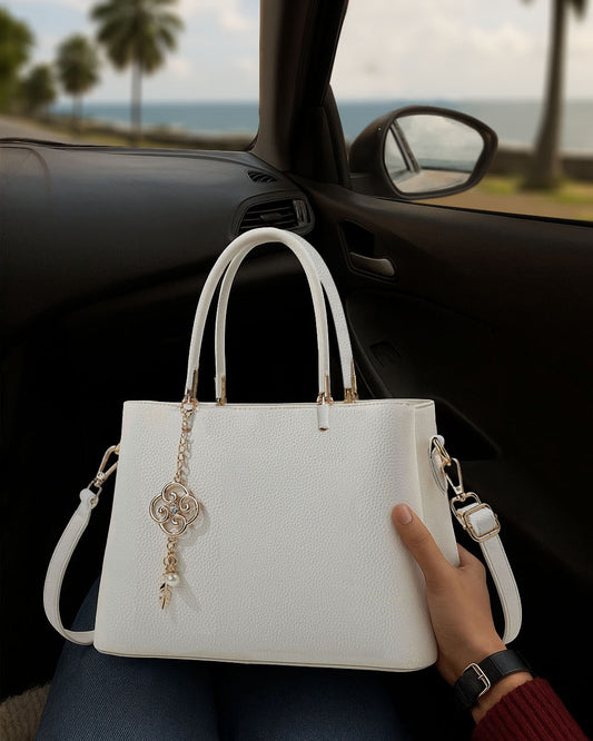 Bolso con dije decorativo y detalles en dorado