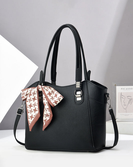 Cartera espaciosa con lazo decorativo, detalles en plateado