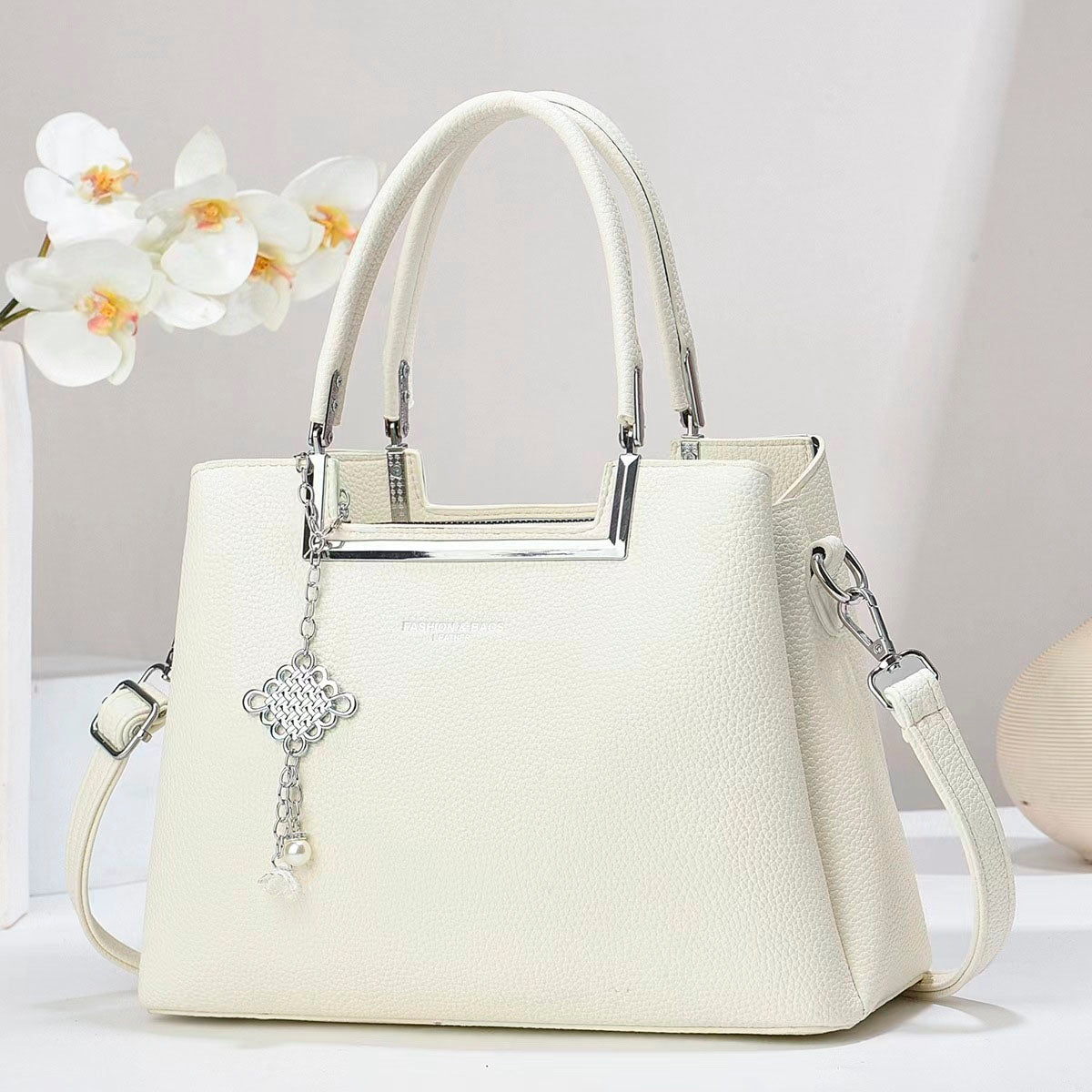 Bolso de mano con asas doble, correa de hombro desmontable. Dije decorativo plateado