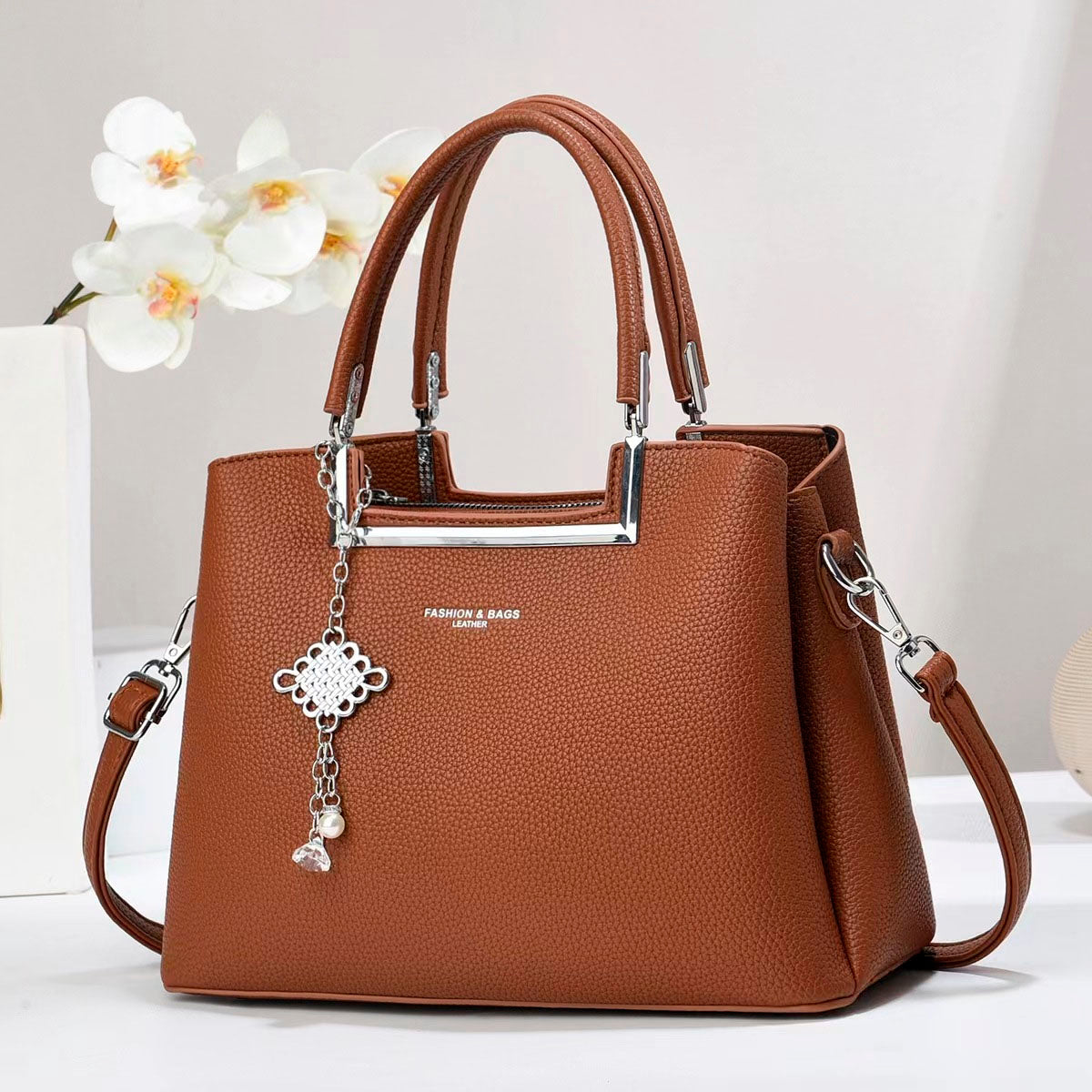 Bolso de mano con asas doble, correa de hombro desmontable. Dije decorativo plateado